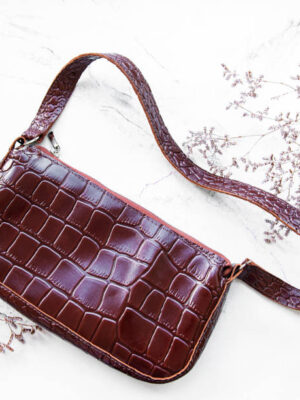 Brown crocodile leather bag on a white background