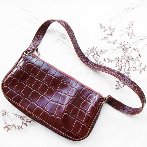 Brown crocodile leather bag on a white background